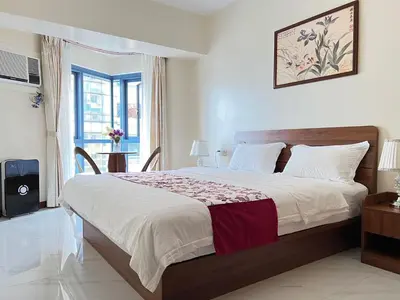 a bedroom with a large bed and a window at Grand Riviera Suites in Manila