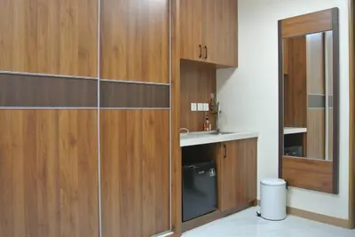 a bathroom with wooden cabinets and a sink and a toilet at Grand Riviera Suites in Manila