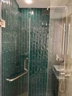 a green tiled bathroom with a shower and a sink at The DRYM Space — Curated Staycation in Mandaluyong in Manila