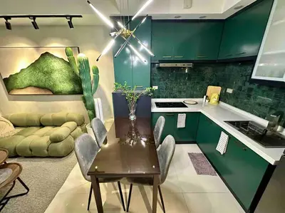 a kitchen with green cabinets and a table with chairs at The DRYM Space — Curated Staycation in Mandaluyong in Manila