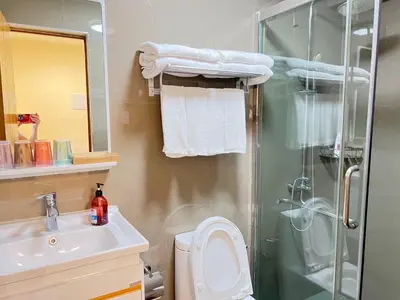 a bathroom with a shower and a toilet and a sink at Partial Ocean View Opposite the US Embassy in Manila