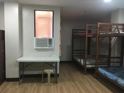 a room with a desk and a window and bunk beds at AGB Anchorage Inn, male dorm in Manila