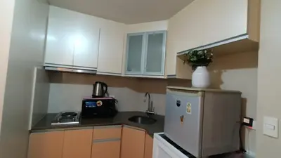 a small kitchen with a refrigerator and a sink at Condotels Near Terminal 3 Airport in Manila