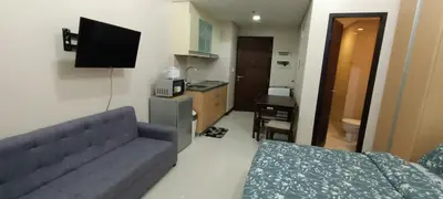 a living room with a couch and a television in it at Condotels Near Terminal 3 Airport in Manila