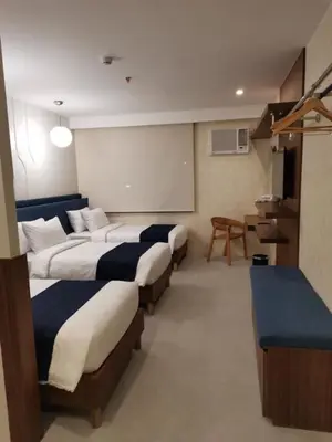 a row of beds in a room with a classroom at Athlete's House in Imus