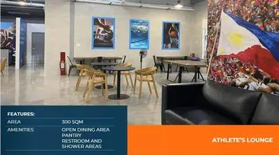 a room with tables and chairs and paintings on the wall at Athlete's House in Imus