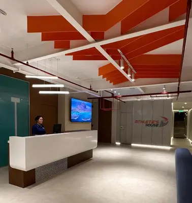 an office lobby with a man standing at a reception desk at Athlete's House in Imus