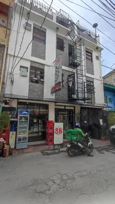 a man on a motorcycle parked in front of a building at SB LODGE TAGUIG in Manila