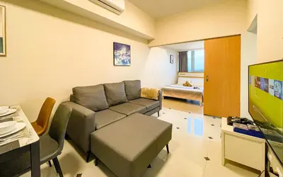 a living room with a couch and a flat screen tv at Cityscape View 2BR in Uptown BGC w 200mbps WiFi in Manila