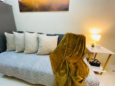a bedroom with a bed with a blanket on it at S Residences Condo PoolView Balcony in SM MOA near NAIA in Manila