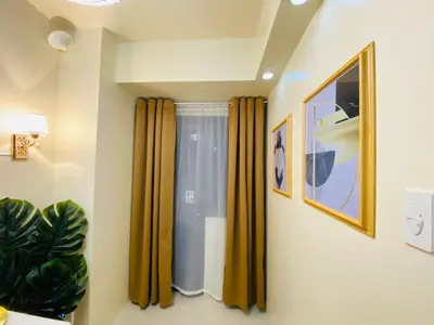 a room with yellow curtains and a window at S Residences Condo PoolView Balcony in SM MOA near NAIA in Manila