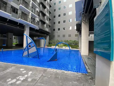 a blue pool with a slide in a building at S Residences Condo PoolView Balcony in SM MOA near NAIA in Manila