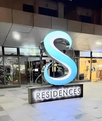 a large blue s sign in front of a store at S Residences Condo PoolView Balcony in SM MOA near NAIA in Manila