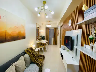 a living room with a couch and a tv at S Residences Condo PoolView Balcony in SM MOA near NAIA in Manila