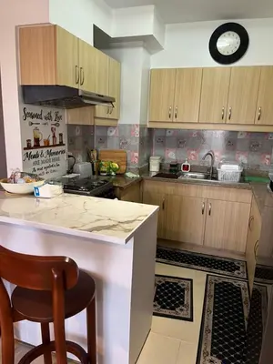 a kitchen with wooden cabinets and a counter top at ALEA RESIDENCES Condo near Airport and MOA! Cozy Place with Main street and Manila Bay view in Manila
