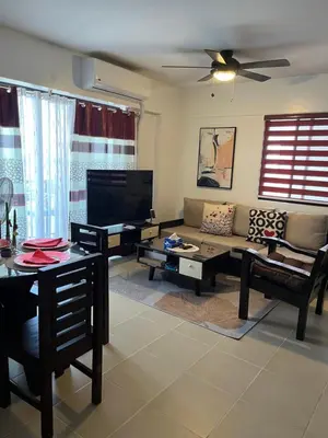 a living room with a couch and a tv at ALEA RESIDENCES Condo near Airport and MOA! Cozy Place with Main street and Manila Bay view in Manila