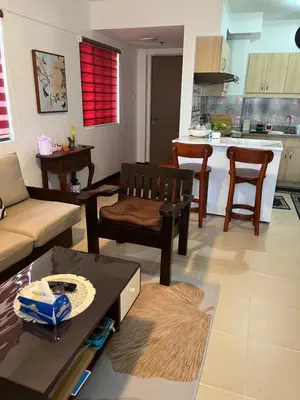 a living room with a couch and a kitchen at ALEA RESIDENCES Condo near Airport and MOA! Cozy Place with Main street and Manila Bay view in Manila
