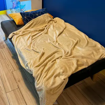 a bed with a blanket on it in a room at Casas Reales Staycation & Rentals in Biñan