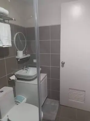 a bathroom with a toilet and a sink and a mirror at Lovely 1 bedroom at Vista Shaw Residences in Manila
