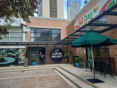 a cafe with a green umbrella in front of a building at Lovely 1 bedroom at Vista Shaw Residences in Manila