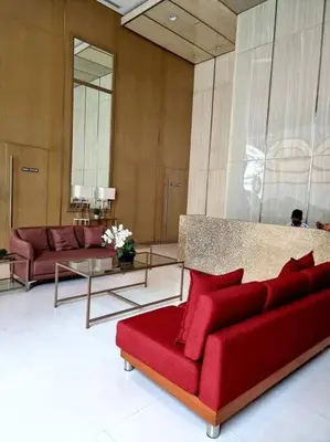 a living room with a red couch and tables at Lovely 1 bedroom at Vista Shaw Residences in Manila
