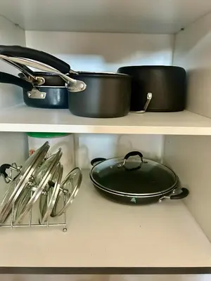 a shelf with pots and pans and other kitchen utensils at BGC, Luxe McKinley Condo at Venice Residences, Free Parking and WiFi in Manila