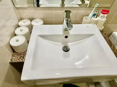 a white sink in a bathroom with toiletries at BGC, Luxe McKinley Condo at Venice Residences, Free Parking and WiFi in Manila