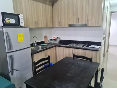 a kitchen with a black table and a refrigerator at SHORE 2 Res TOWER 1 -2 BR unit in Manila