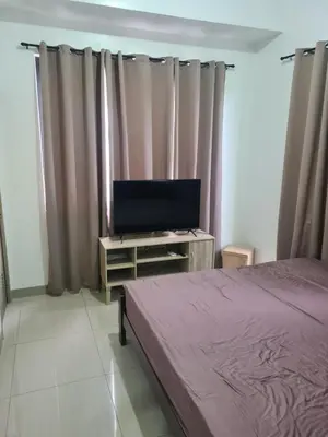 a bedroom with a bed and a flat screen tv at SHORE 2 Res TOWER 1 -2 BR unit in Manila