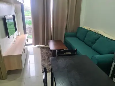 a living room with a green couch and a table at SHORE 2 Res TOWER 1 -2 BR unit in Manila