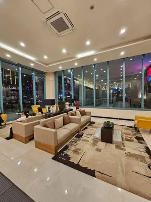 a living room with couches and tables and windows at One Uptown BGC Modern & Spacious, Great Location, 200mbps & washer in Manila