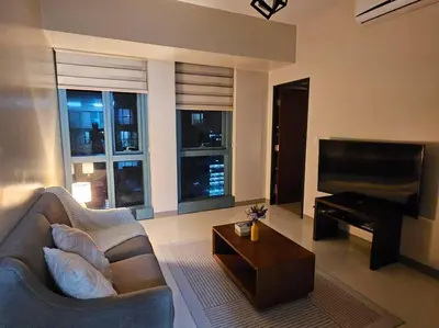 a living room with a couch and a piano at One Uptown BGC Modern & Spacious, Great Location, 200mbps & washer in Manila
