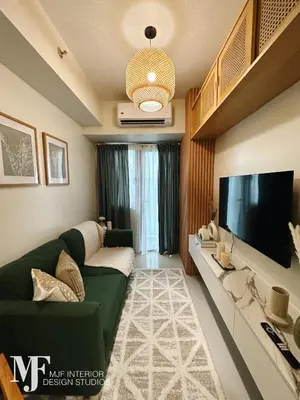 a living room with a green couch and a flat screen tv at Mi Casa in Manila