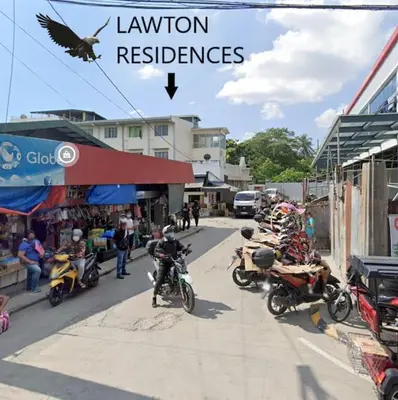 a bird is flying over a street with motorcycles at Lawton Residences Studio Room 3A in Manila