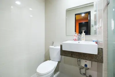 a white bathroom with a toilet and a sink at Family Staycation, Greenbelt Hamilton, Isabel's Makati Rooms in Manila