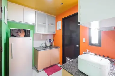 a kitchen with a white refrigerator and a sink at Family Staycation, Greenbelt Hamilton, Isabel's Makati Rooms in Manila