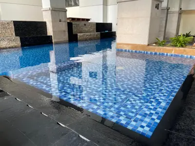a swimming pool with blue tiles in a building at Family Staycation, Greenbelt Hamilton, Isabel's Makati Rooms in Manila