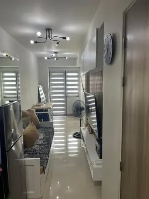a living room with a couch and a clock on the wall at Cozyhome by LV & SG - S residences MOA PASAY unit condo in Manila