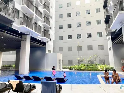 a group of people standing around a swimming pool in a building at Cozyhome by LV & SG - S residences MOA PASAY unit condo in Manila