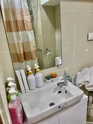 a bathroom with a sink and a mirror at Cozyhome by LV & SG - S residences MOA PASAY unit condo in Manila