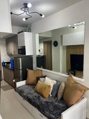 a couch with pillows on it in a living room at Cozyhome by LV & SG - S residences MOA PASAY unit condo in Manila