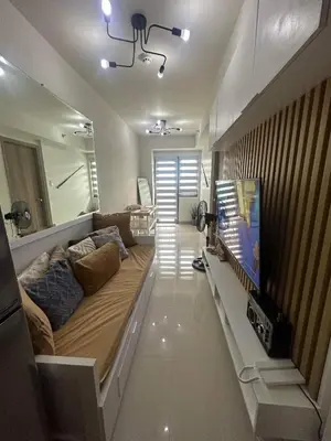a living room with a couch and a flat screen tv at Cozyhome by LV & SG - S residences MOA PASAY unit condo in Manila