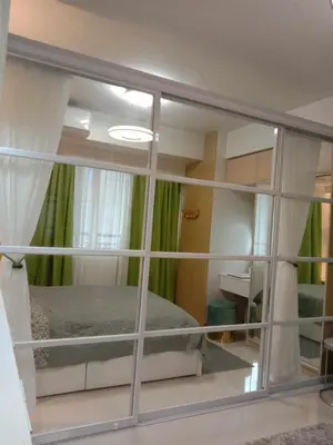 a bedroom with a bed and a mirror at OASIS CHIC By THE BAY PASAY CITY Near Mall of Asia in Manila