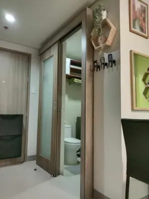 a bathroom with a toilet and a sliding glass door at OASIS CHIC By THE BAY PASAY CITY Near Mall of Asia in Manila