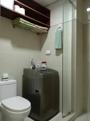 a bathroom with a toilet and a glass shower at OASIS CHIC By THE BAY PASAY CITY Near Mall of Asia in Manila
