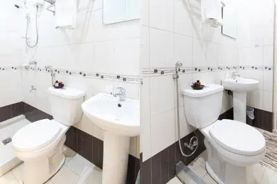 a bathroom with two toilets and a sink at Starlight Bed and Breakfast in Manila