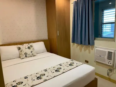 a small bedroom with a bed and a window at Starlight Bed and Breakfast in Manila