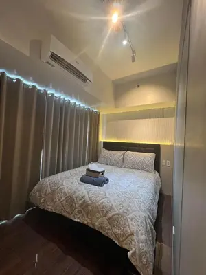 a bedroom with a bed with a white comforter at E & T Homecations 2 Bedroom Apartment at SMDC Air Residences in Manila