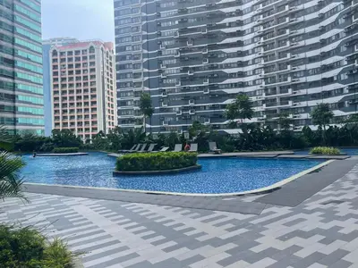 a large swimming pool in a city with tall buildings at E & T Homecations 2 Bedroom Apartment at SMDC Air Residences in Manila