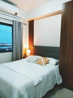 a bedroom with a large white bed with a window at 2BR SMDC Bloom Residences Near NAIA Wi-fi +Netflix in Manila